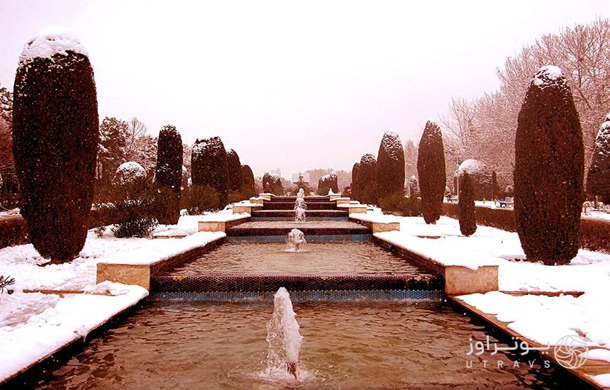 پارک لاله تهران در زمستان که در فضای اطراف حوض‌های پلکانی آن و روی درخت‌های کاج دو سمتش، برف نشسته‌است.
